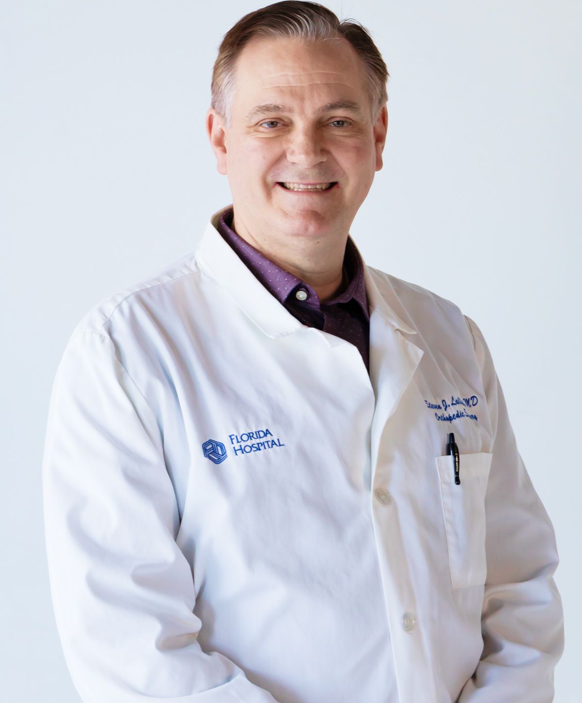 Doctor in white coat smiling for portrait.