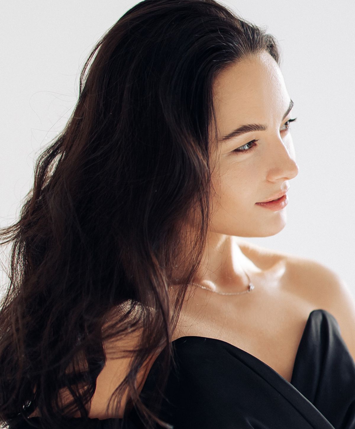 Woman with long hair in black attire.