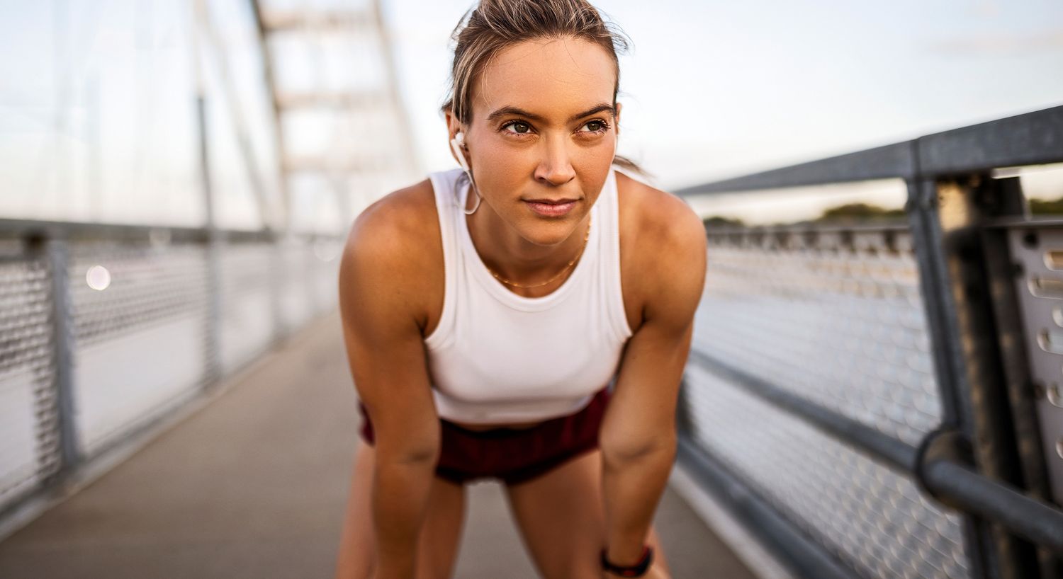 Runner taking a break on a bridge.